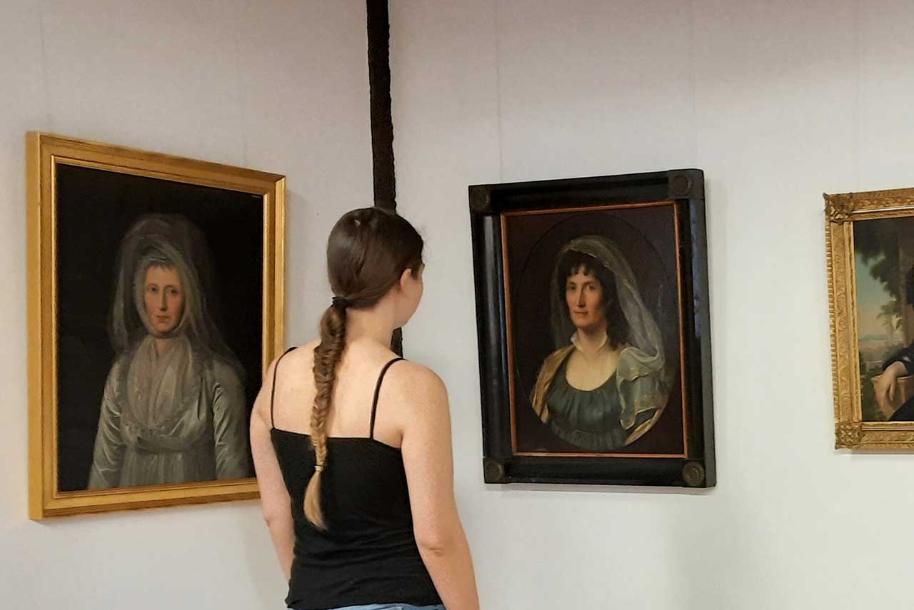 Mädchen steht vor Gemälden